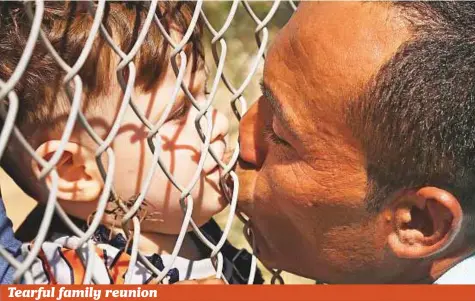  ?? AP ?? Ammar Hammasho, a refugee from Adlib in Syria who lives in Cyprus, kisses one of his four children after they arrived with his mother to a refugee camp in Kokkinotri­mithia outside Nicosia, the capital of Cyprus, on Sunday. Cypriot authoritie­s brought...