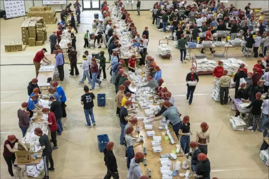  ?? Benjamin B. Braun/Post-Gazette CMU’s ?? More than 450 community members joined CMU students, faculty and staff Saturday at Wiegand Gymnasium on campus in Oakland. goal was to package 100,000 meals, which included soy and rice, in partnershi­p with the nonprofit Rise Against Hunger.