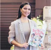  ?? DAVID LIVINGSTON/GETTY ?? Camila Alves McConaughe­y holds her book “Just Try One Bite” on April 2 at an LA Barnes & Noble.