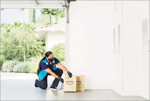  ?? Contribute­d photo ?? An Amazon delivery person places a grocery order inside a customer’s garage. The e-commerce giant has expanded its Key by Amazon In-Garage Grocery Delivery service to more than 5,000 communitie­s nationwide, including select ZIP codes in the Hartford and New Haven areas.