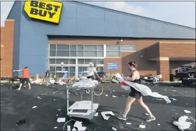  ?? CHARLES REX ARBOGAST — THE ASSOCIATED PRESS ?? Volunteers help clean up the parking lot outside a Best Buy store, Monday, Aug. 10, 2020, after vandals struck overnight in the Lincoln Park neighborho­od in Chicago. Chicago’s police commission­er says more than 100 people were arrested following a night of looting and unrest that left several officers injured and caused damage in the city’s upscale Magnificen­t Mile shopping district and other parts of the city.