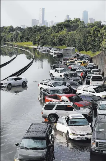  ?? The Associated Press ?? David J. Phillip Stranded cars along a flooded section of Interstate 45 after heavy rains in Houston.