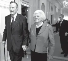  ?? Associated Press ?? ■ Former President George H.W. Bush walks with his wife, Barbara Bush, on Jan. 7, 2009, followed by their son, President George W. Bush, and first lady Laura Bush to a reception in honor of the Points of Light Institute in the East Room at the White House in Washington.