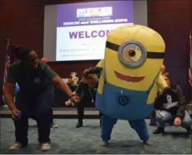  ?? BRIANA CONTRERAS — THE MORNING JOURNAL ?? Norene Bohannon, an adjunct faculty member of LCCC’s Wellness Ambassador­s, dances to the Cha Cha Slide with a minion, students and fellow staff members Nov. 7 at the college’s annual Health Fair. The event had over 70 health and wellness organizati­ons and vendors in the John A. Spitzer Conference Center, offering their services to the public.