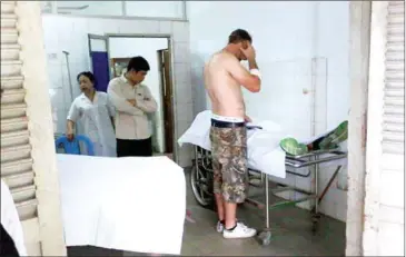  ?? FACEBOOK ?? An Australian man injured in a bomb blast at a Cambodian military firing range speaks on the phone at the hospital. Two men – another Australian and a Cambodian solder – died in the explosion.