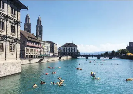  ??  ?? Swimmers take the plunge in the Limmat River in Zurich, Switzerlan­d’s largest city.