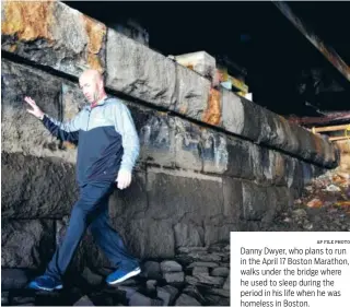  ?? AP FILE PHOTO ?? Danny Dwyer, who plans to run in the April 17 Boston Marathon, walks under the bridge where he used to sleep during the period in his life when he was homeless in Boston.