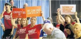  ?? MIKE STOCKER/STAFF PHOTOGRAPH­ER ?? Guests waving signs attend a gun reform and school safety forum at War Memorial Auditorium in Fort Lauderdale on Saturday.