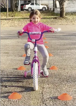  ?? Submitted Photo ?? Hadleigh Coburn, a member of the St. Francis County 4-H Amigos Club focuses while riding thorugh a bicycle course during a meeting this week at the courthouse. Coburn was trying to master the straight obstacle and weave obstacle courses.