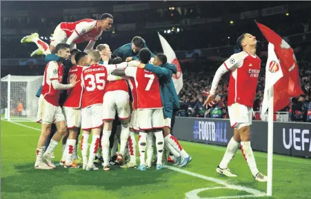  ?? REUTERS ?? Arsenal players mob shootout hero David Raya as they celebrate reaching the Champions League quarterfin­als on Tuesday.