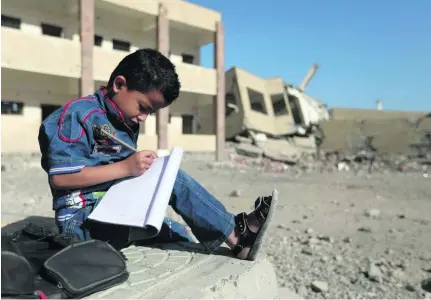  ?? Ahmad Al Basha / AFP ?? A Yemeni boy outside a school that was damaged in an air strike in the south-western Yemeni city of Taez.