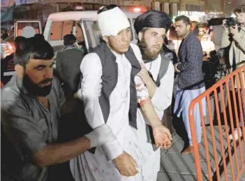  ?? — Reuters ?? Afghan men carry an injured person to a hospital after a suicide attack in Kabul on Tuesday.