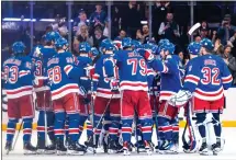  ?? PETER K. AFRIYIE — THE ASSOCIATED PRESS ?? New York Rangers players gather on the ice after Adam Fox’s overtime goal against the Philadelph­ia Flyers in an NHL hockey game Tuesday, March 26, 2024 in New York.