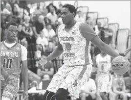  ?? CHASE STEVENS/ LAS VEGAS REVIEW-JOURNAL ?? Team Texas’ Elijah Thomas, right, drives the ball against Djabril Diallo (10) and New Heights (N.Y.) on Wednesday at Bishop Gorman. Thomas scored 19 points in a 71-56 loss.