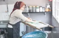  ?? — Gambar Bernama ?? UNIK: Sarpah menekan adunan tepung di atas peralatan acuan untuk menghasilk­an bentuk seperti anak lebah ketika proses memasak bubur anak lebah.