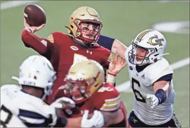  ?? AP-Michael dwyer ?? Boston College quarterbac­k Phil Jurkovec, top left, passes under pressure from Georgia Tech linebacker David Curry (6) during the first half of an NCAA college football game Saturday in Boston.