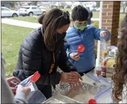  ??  ?? Margo Levin, and Samuel Weiss, 9, both of Wyomissing, work with other volunteers to assemble Spanish Rice mixes at the Immanuel United Church of Christ in Shillingto­n Monday morning during a program for Martin Luther King Jr. Day. The church and the Jewish Federation of Reading/ Berks sponsored the event.