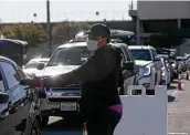  ?? Lisa Krantz / Staff photograph­er ?? Jakema Manchester directs traffic Friday at the mega food distributi­on at Gustafson Stadium.