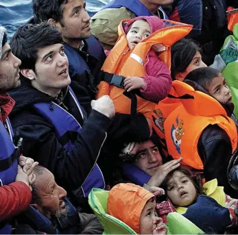  ??  ?? Crammed in: Migrants, many of them children, on board a rubber dinghy at