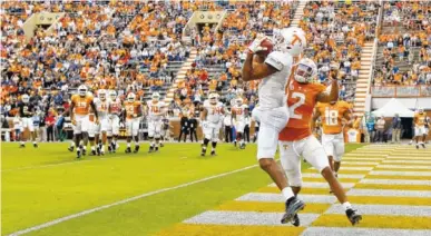  ?? STAFF PHOTO BY C.B. SCHMELTER ?? Tennessee’s Jauan Jennings pulls in a touchdown pass against defensive back Alontae Taylor during the Orange and White game in April at Neyland Stadium.