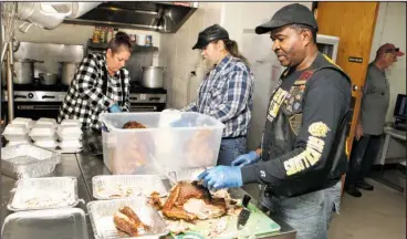  ?? The Sentinel-Record/Richard Rasmussen ?? TURKEY CARVING: Volunteers Melissa Allen, left, Jerry Allen and Emanuel Jernigal assist in preparing the Salvation Army’s Annual Community Thanksgivi­ng Dinner on Wednesday. The Salvation Army purchased 25 turkeys and projects they will feed...