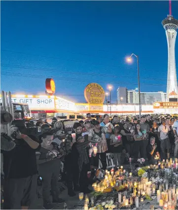  ??  ?? Mourners attend a vigil for the victims of the mass shooting at the Route 91 Harvest country music festival in Las Vegas.