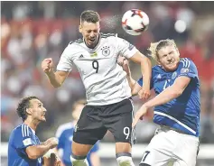  ??  ?? Germanys midfielder Sandro Wagner (centre) gets up higher than San Marino’s defender Alessandro Della Valle (left) and San Marino’s defender Juri Biordi to score the seventh goal during the FIFA World Cup 2018 qualificat­ion football match between...