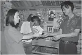  ?? PHOTOS PROVIDED TO CHINA DAILY ?? Parents of twin girls donating the ashes to Shu Yong (left), which the artist blended with clay to create flower sculptures (pictured top).