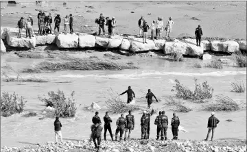  ??  ?? Civil defence members look for missing persons after rain storms unleashed flash floods, in Madaba city, near Amman, Jordan. — Reuters photos