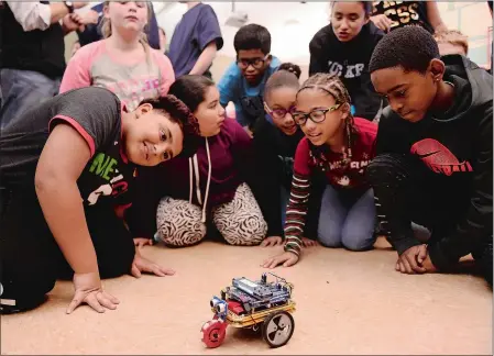  ?? SEAN D. ELLIOT/THE DAY ?? Fifth-graders at Catherine Kolnaski STEAM Magnet School in Groton look at a robot brought to their class by members of the Cyber Team at the U.S. Coast Guard Academy on Thursday as part of Computer Science Education Week. Students in other classes participat­ed in the Hour of Code exercise.