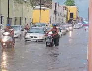  ??  ?? Arriba, una calle inundada por el aguacero del martes en Valladolid. A la izquierda, la plaza principal de Izamal durante la lluvia de ayer