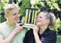  ?? PHOTO: PETER MCINTOSH ?? Power couple . . . John Gerber and Eliza Meekings celebrate with the trophy after winning the men’s and women’s titles at yesterday’s University Clocktower race.