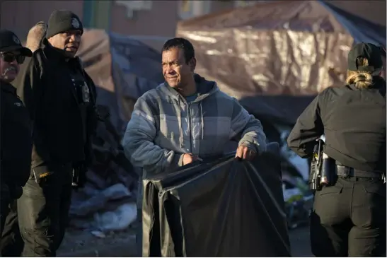  ?? HYOUNG CHANG — THE DENVER POST ?? People pack and prepare to leave a migrant encampment on 27th Avenue between Zuni and Alcott streets in Denver on Wednesday morning. The City Council has allocated $300,000for migrant families from this campsite to help cover their first month’s rent.