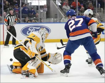  ?? MARY ALTAFFER — THE ASSOCIATED PRESS ?? New York Islanders left wing Anders Lee (27) scores a goal past Pittsburgh Penguins goaltender Casey DeSmith (1) during the second period of an NHL hockey game, Friday, Feb. 17, 2023, in Elmont, N.Y.
