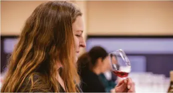  ?? PHOTOS BY BRIAN FEULNER ?? Above: Amanda Garland, estate host at Matanzas Creek Winery, evaluates a wine at the competitio­n. Right: Denise Gill, tasting room manager at Alexander Valley Vineyards, judges a red wine category with 10 to 14 wines of a single varietal.