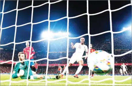  ?? JORGE GUERRERO/AFP ?? England forward Raheem Sterling (right) scores against Spain goalkeeper David de Gea (left) during their UEFA Nations League match on Monday night at the Benito Villamarin stadium in Sevilla.
