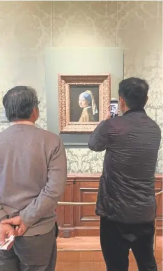  ?? // K.S.B. ?? Dos visitantes fotografía­n ‘La joven de la perla’, en el Mauritshui­s