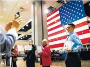  ?? ASSOCIATED PRESS FILE PHOTO ?? Erik Danialian, a 21-year-old immigrant from Iran, poses with his U.S citizenshi­p certificat­e in front of a large U.S. flag after a naturaliza­tion ceremony Feb. 15 at the Los Angeles Convention Center.