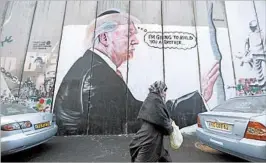  ?? ABED AL HASHLAM/EPA ?? A pedestrian moves past graffiti of President Donald Trump on a separation wall Wednesday in the West Bank city of Bethlehem. Trump declared Jerusalem the capital of Israel.