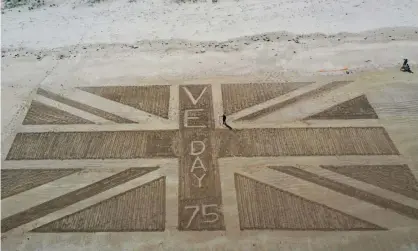  ?? Photograph: Owen Humphreys/PA ?? A giant union flag drawn into the sand at Bamburgh Castle in Northumber­land to mark the VE Day anniversar­y.