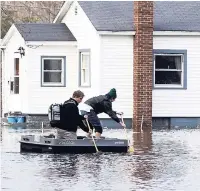  ?? AP ?? People navigate on a flooded street in Niles, Michigan, on Thursday. Flooding is expected to continue through the weekend in Michigan, Indiana and other Midwest states that have been swamped by high water from heavy rains and melting snow.