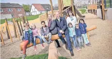  ?? FOTO: GMG ?? Auf dem Spielplatz im neuen Wohngebiet Butschenwe­g können die Kinder klettern, rutschen und toben. Thomas Küppers, Beatrice Kamper und Claudia Goll (r.) von der Grundstück­s-Marketing-Gesellscha­ft haben ihn eröffnet.