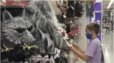  ?? AP ?? SPEND TREND: A customer checks out Halloween masks at Party City in Miami.