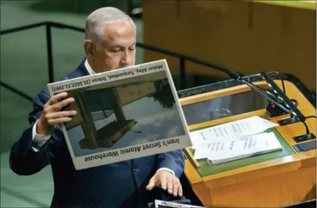  ?? CRAIG RUTTLE — THE ASSOCIATED PRESS ?? Israeli Prime Minister Benjamin Netanyahu prepares to display a photograph as he addresses the 73rd session of the United Nations General Assembly, at U.N. headquarte­rs, Thursday.