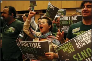  ?? (Seattle Times/Erika Schultz) ?? Lupe Sanchez (center) cheers as the Seattle City Council unanimousl­y approves a secure scheduling law for workers in Seattle in 2016.