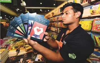  ?? Atiq Ur Rehman/Gulf News ?? Salesman Sangeeth Sajilal with copies of William Shakespear­e’s classics at the Sharjah book fair.