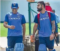  ?? PTI ?? Kohli and Dhoni share a light moment during a practice session ahead of the second ODI against Australia. —