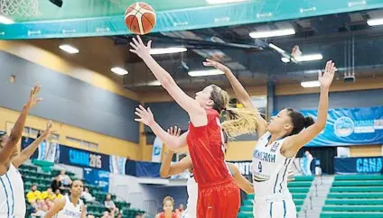  ??  ?? La boricua Allison Gibson ataca al canasto frente a la defensa quisqueyan­a durante el errático desafío. Puerto Rico tiró de campo para 28%, y 26% de Dominicana, con 33 ‘turnovers’.