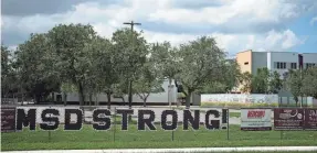  ?? PHOTOS BY REBECCA BLACKWELL/AP ?? Behind a chain-link fence, Marjory Stoneman Douglas High School in Parkland, Fla., shown Wednesday, has remained a constant, looming reminder of the tragedy for the school’s 3,000 students, staff and anyone who drives past.