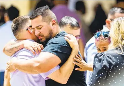  ?? BRANDON BELL GETTY IMAGES ?? People embrace outside Sacred Heart Catholic Church in Uvalde, Texas, where a funeral service was held Tuesday for 10-year-old Amerie Jo Garza. Amerie was among those killed in the mass shooting at Robb Elementary School.